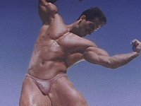 A stud in a tiny thong shows off his huge muscles